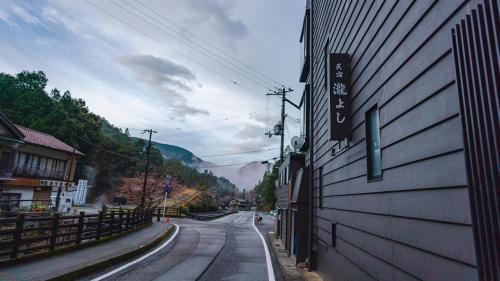 an empty street next to a building in a town at Guest House Takiyoshi in Hongu