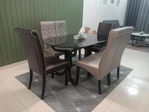 a dining room table and chairs in a room at Homestay Bonda, Taman Mayung, Teluk Kemang - Private Children Pool - Malay Only in Kampung Teluk Kemang