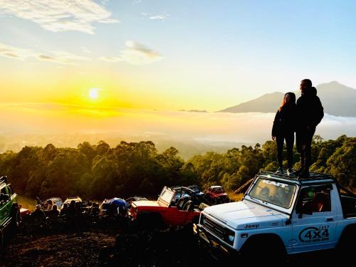a man and woman standing on top of a truck at Batur Caldera Guesthouse in Kintamani