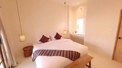a bedroom with a bed with white sheets and a window at 23 PAI HOUSE boutique hotel in Pai