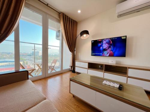 sala de estar con TV de pantalla plana en la pared en Sky Halong Apartment en Ha Long
