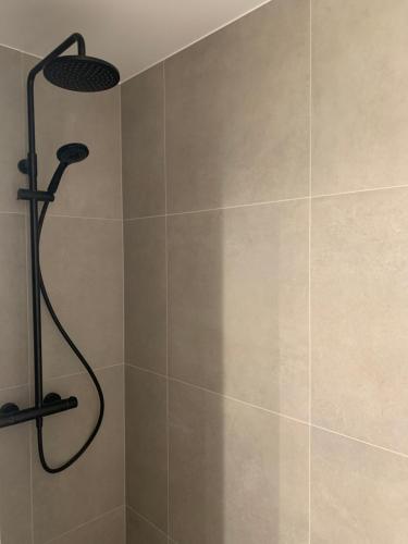 a shower with a shower head in a bathroom at B&B Silentium in Tielt
