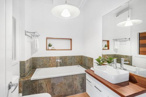 a bathroom with a tub and a sink at Belle Escapes Tropical Haven Holiday Home Palm Cove in Palm Cove