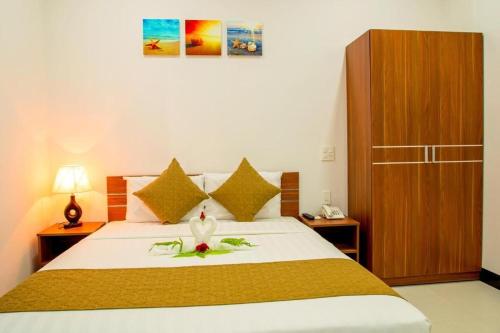 a bedroom with a large bed with a flower on it at PHAM GIA HOTEL Mui Ne in Mui Ne