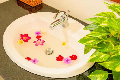 a white bathroom sink with flowers on it at PHAM GIA HOTEL Mui Ne in Mui Ne