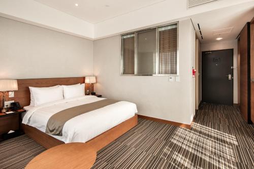 a hotel room with a bed and a window at Golden Tulip Incheon Airport Hotel in Incheon