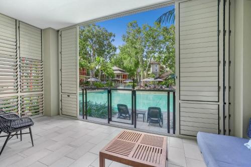an indoor patio with a view of a swimming pool at Belle Escapes 104 Swim-out Luxury Apartment in Palm Cove in Palm Cove