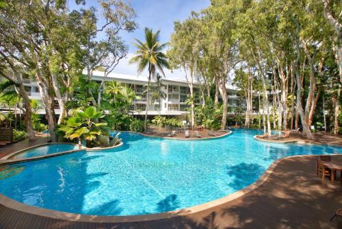a large pool with trees in front of a building at Belle Escapes Beachview Suite 1304 Drift Beachfront Resort in Palm Cove