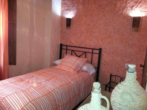 a bedroom with a bed and two vases on the floor at Casa Mirador San Pedro in Arcos de la Frontera