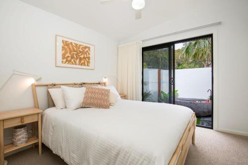 a bedroom with a white bed and a window at Rest Pet Friendly with Outdoor Bath 3 Mins Walk to Beach in Umina