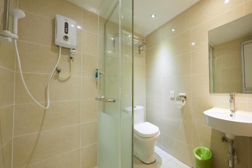 ein Bad mit einer Dusche, einem WC und einem Waschbecken in der Unterkunft SunGold Inn in Kuala Lumpur
