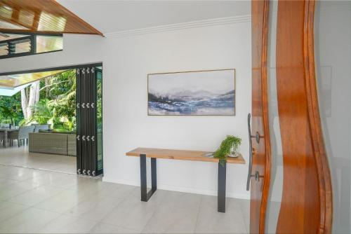 a wooden table in a room with a potted plant at Belle Escapes 58 Ocean Dr Luxury Home Palm Cove in Palm Cove