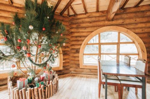 a christmas tree in a room with a table at The Nordic Village - Evergreen Retreat in Mộc Châu
