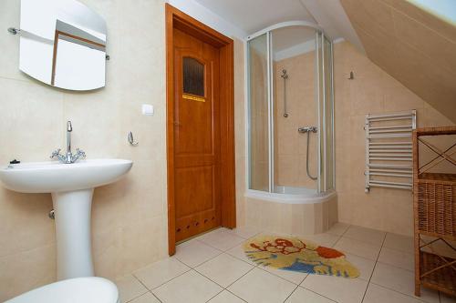 a bathroom with a sink and a shower at Pensjonat Belona in Dziwnów