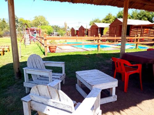una mesa de picnic y sillas frente a un parque infantil en Cabañas Los Búhos en Tristán Suárez