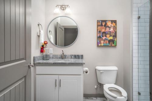 a bathroom with a sink and a mirror and a toilet at The Davis Lofts at Main Street - Unit 1E in Rocky Mount