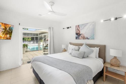 1 dormitorio con 1 cama grande y paredes blancas en Belle Escapes Villa Rosa just minutes to Trinity Beach en Trinity Beach