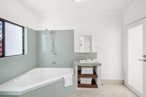 La salle de bains est pourvue d'une baignoire et d'un lavabo. dans l'établissement Belle Escapes Villa Rosa just minutes to Trinity Beach, à Trinity Beach