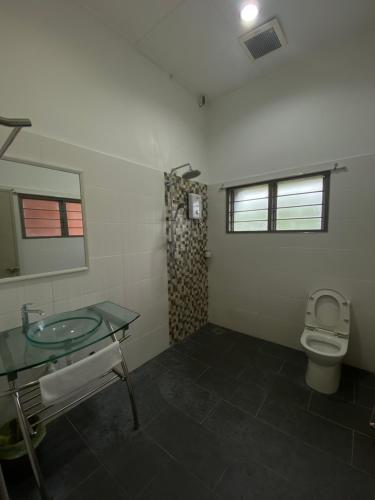 uma casa de banho com um lavatório e um WC em Raintown inn taiping em Taiping