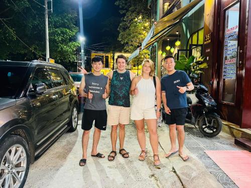 a group of people standing next to a car at Minh Quang Hotel in Dong Hoi