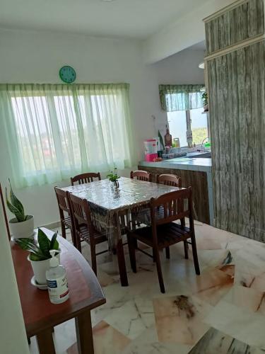 une salle à manger avec une table et des chaises dans l'établissement teluk kemang senorita homestay, à Port Dickson