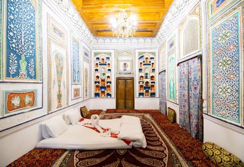 a room with paintings on the walls and a bed at Bukhara Zaringiz PREMIUM in Bukhara