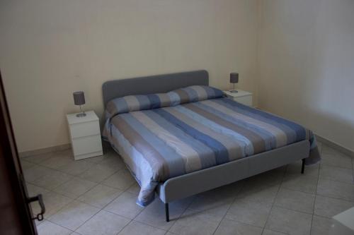 ein Bett in einem Schlafzimmer mit zwei Nachttischen in der Unterkunft Casa Contemare in Viagrande