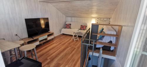 ein kleines Wohnzimmer mit einem TV und einem Sofa in der Unterkunft Vacation Home Kovachnica (Blacksmith`s shop) in Vrbnik