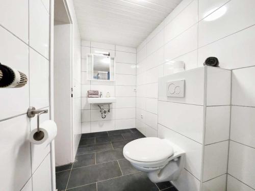 Baño blanco con aseo y lavamanos en 1 Room Apartment in Burscheid, en Burscheid