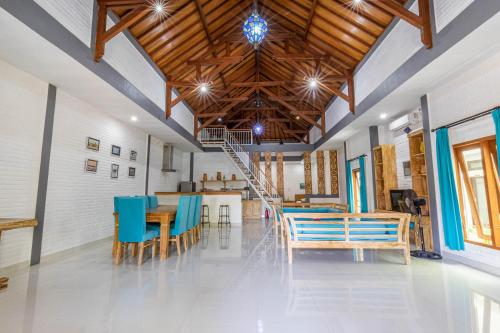 a dining room with blue chairs and a wooden ceiling at Surf Retreat Villa Sari Bali in Pulukan