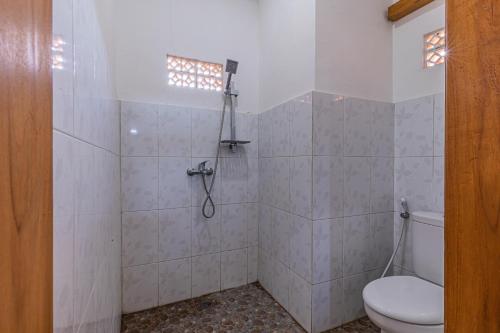 a bathroom with a toilet and a shower at Surf Retreat Villa Sari Bali in Pulukan