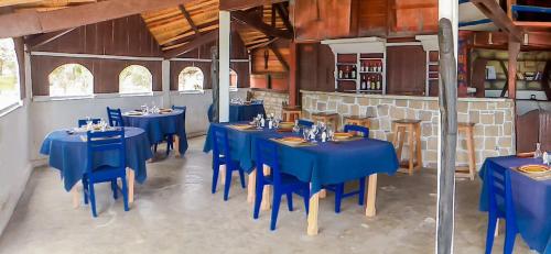 jadalnia z niebieskimi stołami i niebieskimi krzesłami w obiekcie Hôtel SudSud-Itampolo 