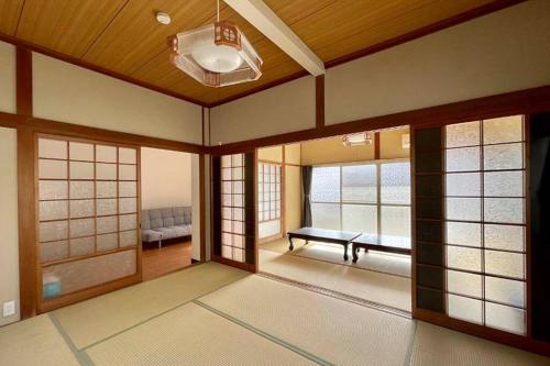 een woonkamer met een bank en ramen bij Guest House Koyama -南紀白浜 ゲストハウス 小山- ペット可 in Asso