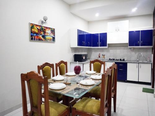 a kitchen and dining room with a table and chairs at Welcome Guest House in Karachi