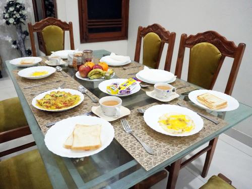 a table with plates of breakfast food on it at Welcome Guest House in Karachi
