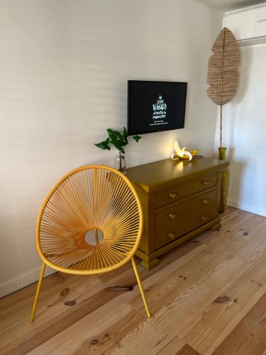 a yellow chair and a dresser in a room at Monkey Tree Stay in Schiedam