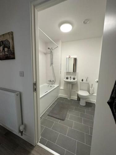 Baño blanco con aseo y lavamanos en NEW Modern 2 Bedroom Apartment!, en Dagenham