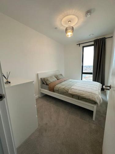 a bedroom with a bed and a window at NEW Modern 2 Bedroom Apartment! in Dagenham