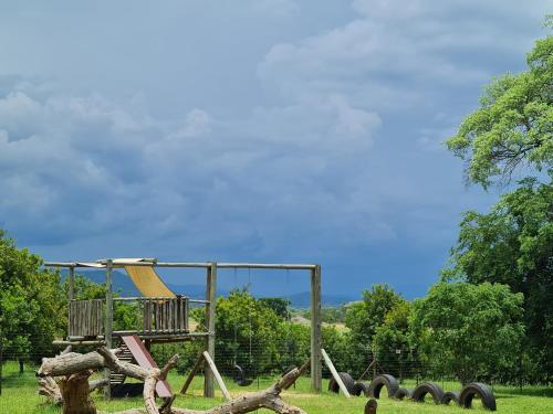 a playground in a park with a swing set at Kiaat Bungalows in Hazyview