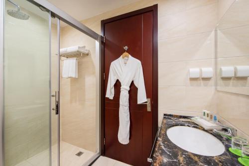 a robe hanging on a door in a bathroom at Holiday Inn Beijing Airport Zone, an IHG Hotel in Shunyi