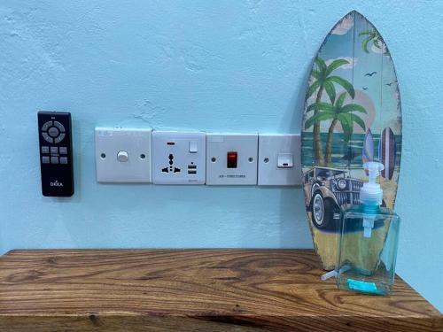 a surfboard on top of a table with a remote control at Entire House . 4 beds . EE Summer Guest House in Seremban