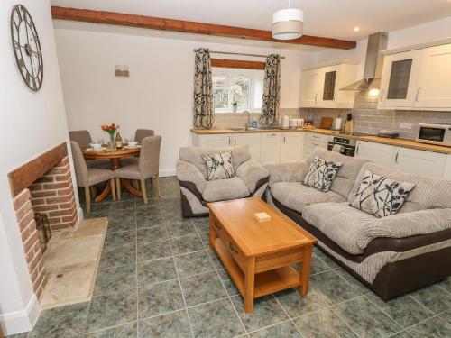 a living room with two couches and a table at Dairy Cottage in Newport