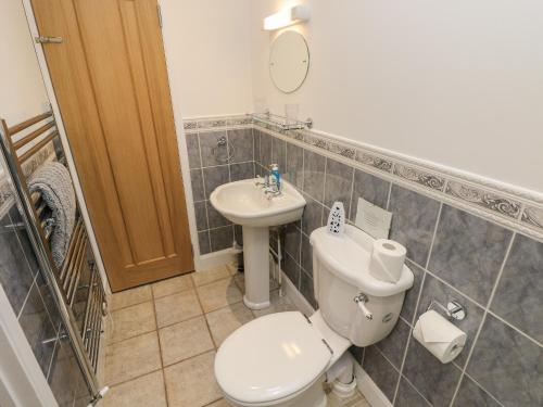 a bathroom with a toilet and a sink at Dairy Cottage in Newport