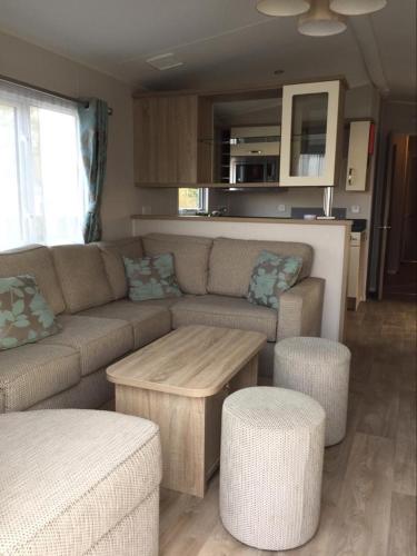 un salon avec un canapé et une table dans l'établissement Assist' Mobil Home Grand mobil home 3 chambres proche châteaux de la Loire AMHCH9, à Onzain
