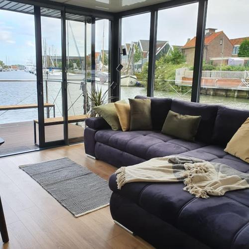 a living room with a couch and a view of the water at Modern, brand new houseboat near Amsterdam in Monnickendam