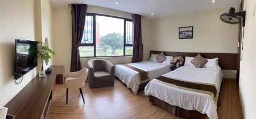 a hotel room with two beds and a tv at Song Kieu Hotel - Self check-in in Ha Long