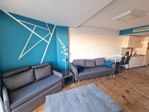 a living room with two couches and a painting on the wall at Seaside Park Private Apartment by Villmaris in Kołobrzeg