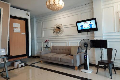 a living room with a couch and a flat screen tv at Pondok Sabaraya Haji Juanda Cikampek Purwakarta in Karawang