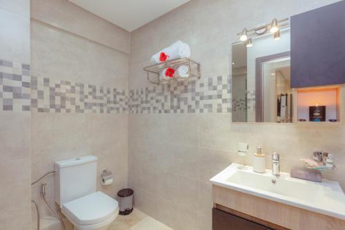 La salle de bains est pourvue de toilettes, d'un lavabo et d'un miroir. dans l'établissement Cozy 2-bedroom apartment in Gueliz, Marrakech, à Marrakech
