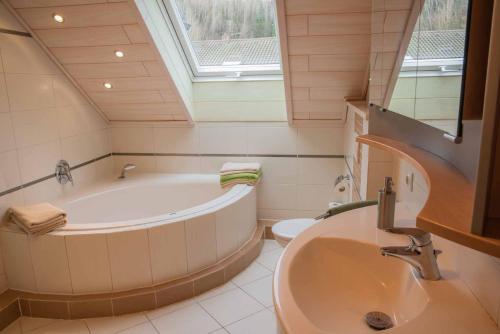 a bathroom with a tub and a toilet and a sink at Ferienwohnung Ebert in Steinwiesen